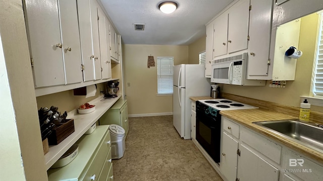 kitchen featuring white cabinets, white appliances, and sink