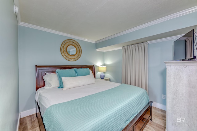 bedroom with crown molding and light hardwood / wood-style floors