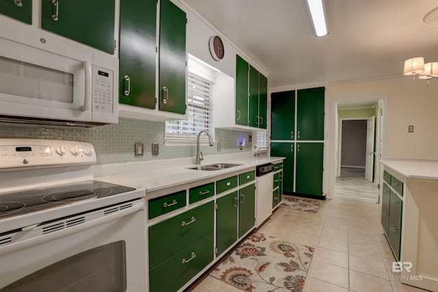 kitchen featuring sink, white appliances, light tile patterned floors, green cabinets, and backsplash