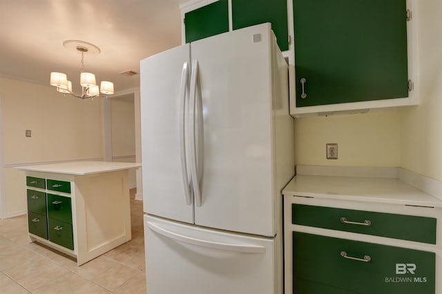 kitchen featuring pendant lighting, white fridge, light tile patterned floors, a notable chandelier, and green cabinetry