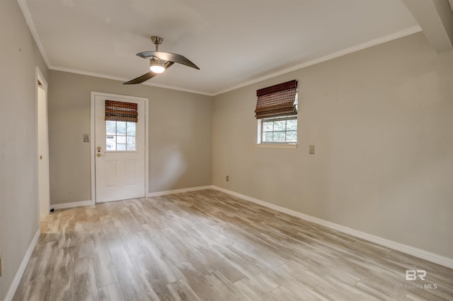 spare room with ornamental molding, a healthy amount of sunlight, and light wood-type flooring