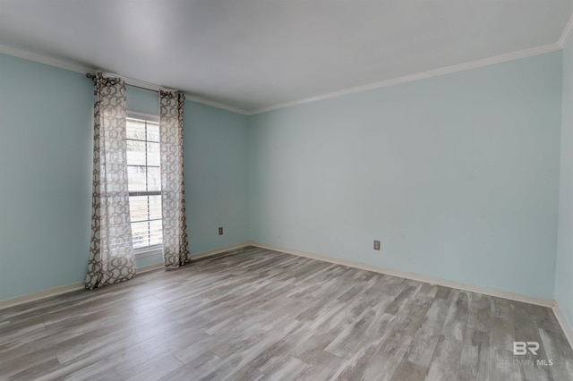 empty room featuring ornamental molding and light hardwood / wood-style floors