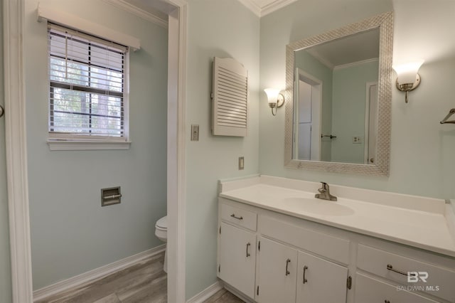 bathroom featuring vanity, hardwood / wood-style floors, ornamental molding, and toilet