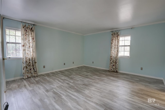 empty room with ornamental molding and light hardwood / wood-style floors