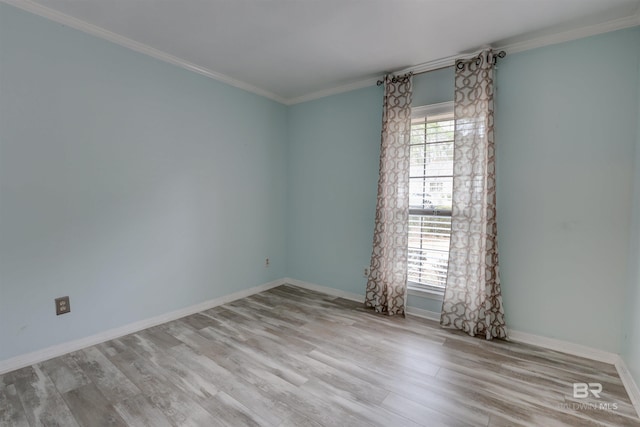 empty room with crown molding and light hardwood / wood-style floors