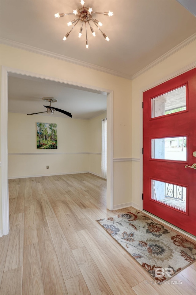 entrance foyer featuring crown molding, ceiling fan with notable chandelier, and light hardwood / wood-style floors