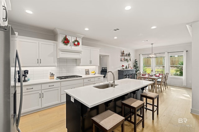 kitchen featuring sink, white cabinets, stainless steel appliances, and light wood-type flooring