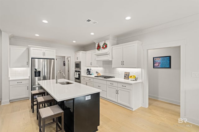 kitchen with white cabinets, light wood-type flooring, sink, and appliances with stainless steel finishes