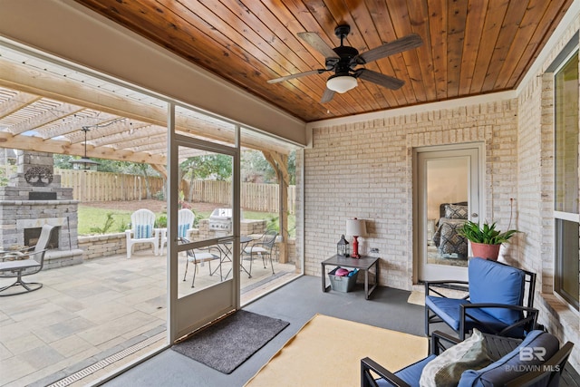 sunroom featuring ceiling fan and wooden ceiling