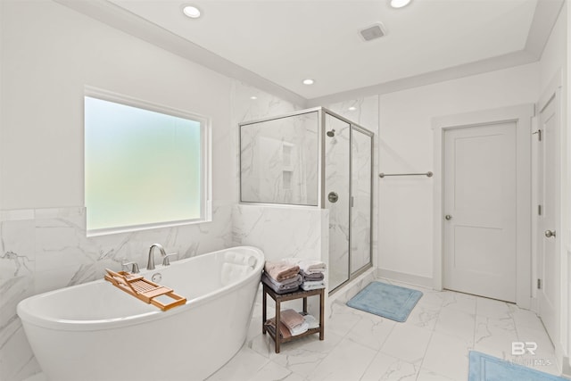 bathroom with tile walls and shower with separate bathtub