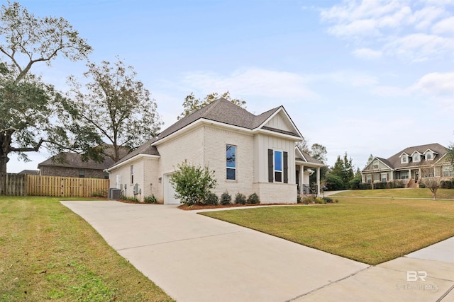 view of front of property with central air condition unit, a front lawn, and a garage