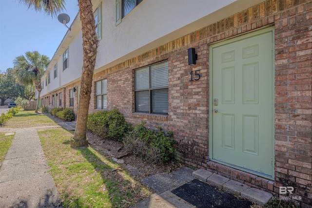 property entrance featuring brick siding