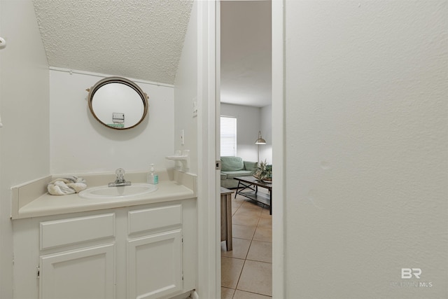 bathroom with vanity, a textured ceiling, and tile patterned floors