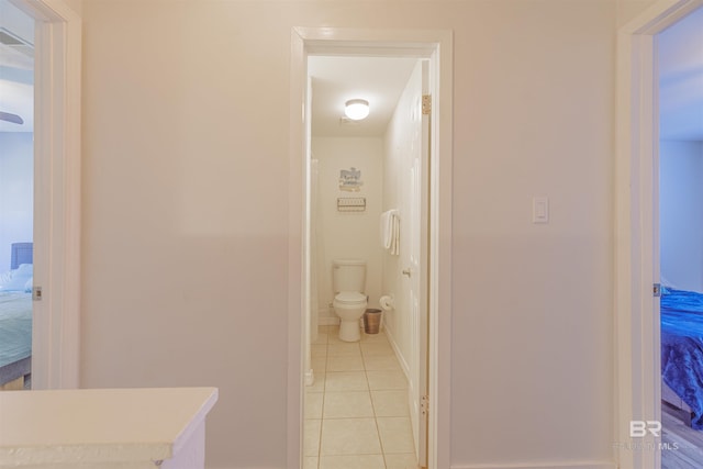 bathroom featuring tile patterned flooring, connected bathroom, and toilet