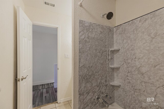 full bathroom featuring baseboards, visible vents, shower / bathtub combination, and tile patterned floors