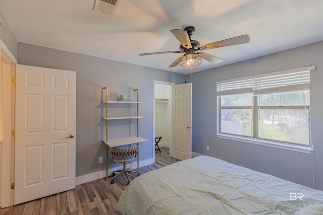 bedroom with baseboards, visible vents, ceiling fan, and wood finished floors