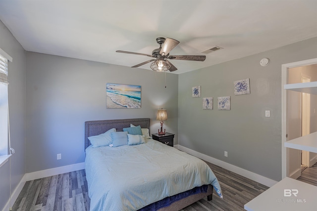 bedroom featuring a ceiling fan, baseboards, visible vents, and wood finished floors