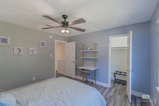 bedroom with light wood-style floors, visible vents, baseboards, and a ceiling fan