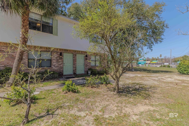 view of front of property featuring brick siding and stucco siding