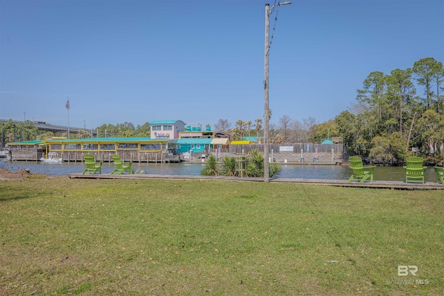 view of dock with a water view and a yard