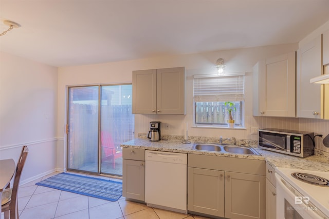 kitchen with a sink, plenty of natural light, stainless steel microwave, and dishwasher