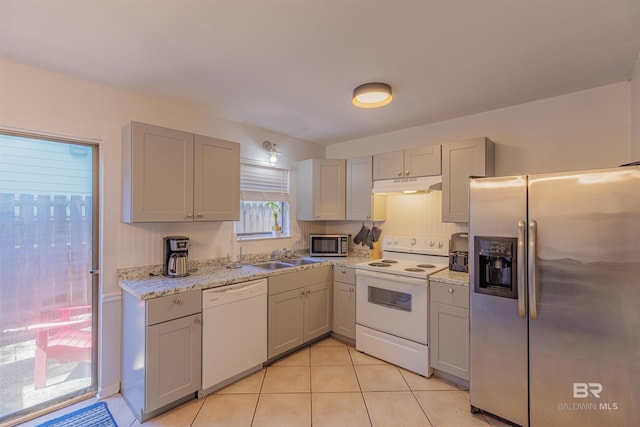 kitchen with appliances with stainless steel finishes, a sink, under cabinet range hood, and gray cabinetry