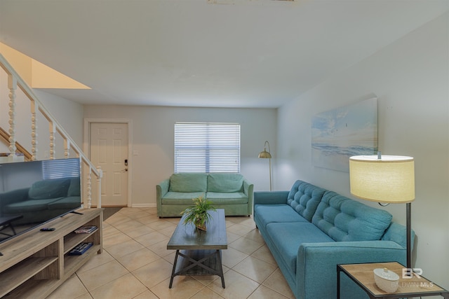 living room featuring light tile patterned floors and stairs