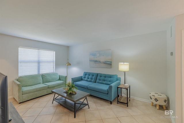 living room with light tile patterned flooring, visible vents, and baseboards