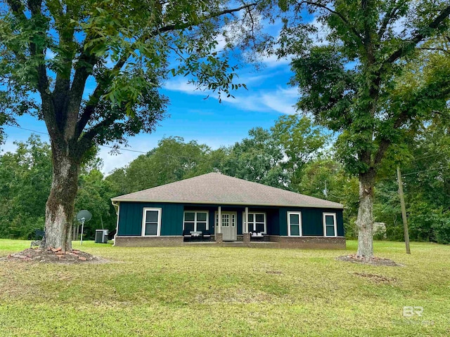 ranch-style house featuring a front lawn and central AC unit