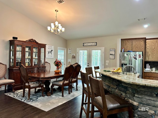 dining space with an inviting chandelier, vaulted ceiling, dark hardwood / wood-style floors, and french doors