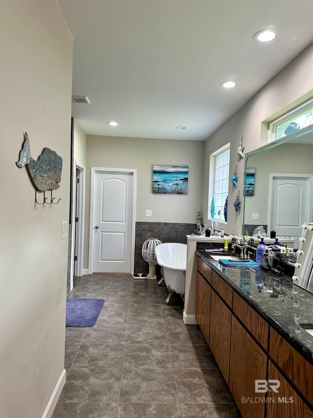 bathroom with tile patterned flooring, vanity, and a bathing tub