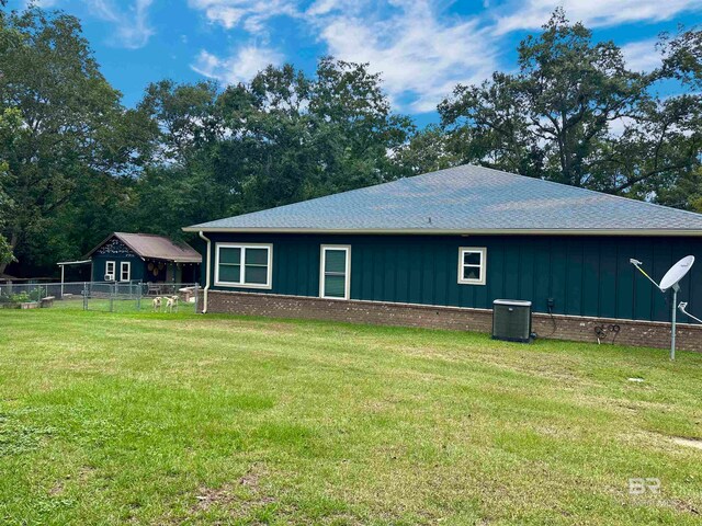 view of side of property with a yard and central AC unit