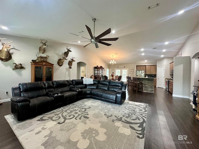 living room with ceiling fan with notable chandelier, vaulted ceiling, and dark wood-type flooring