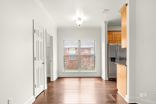 unfurnished dining area with visible vents, dark wood-type flooring, and ornamental molding