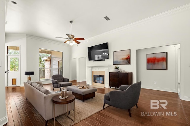 living room featuring visible vents, ornamental molding, wood finished floors, and a high end fireplace