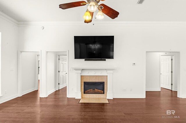 unfurnished living room with a fireplace, ornamental molding, a ceiling fan, wood finished floors, and baseboards