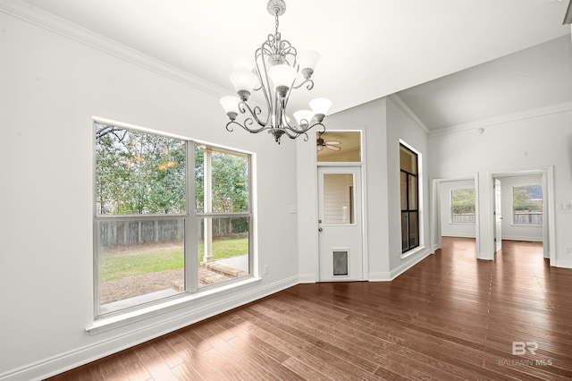 unfurnished dining area featuring an inviting chandelier, baseboards, dark wood finished floors, and crown molding