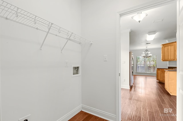 laundry area featuring hookup for a washing machine, dark wood-style flooring, a chandelier, and baseboards