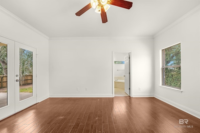 spare room featuring french doors, crown molding, baseboards, and wood finished floors