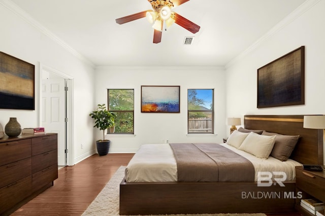 bedroom with visible vents, baseboards, dark wood-style flooring, and crown molding