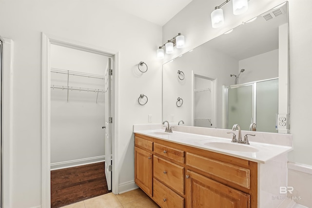 full bath with tile patterned flooring, a sink, visible vents, and a shower stall