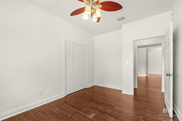 unfurnished bedroom with baseboards, visible vents, ceiling fan, wood finished floors, and a closet