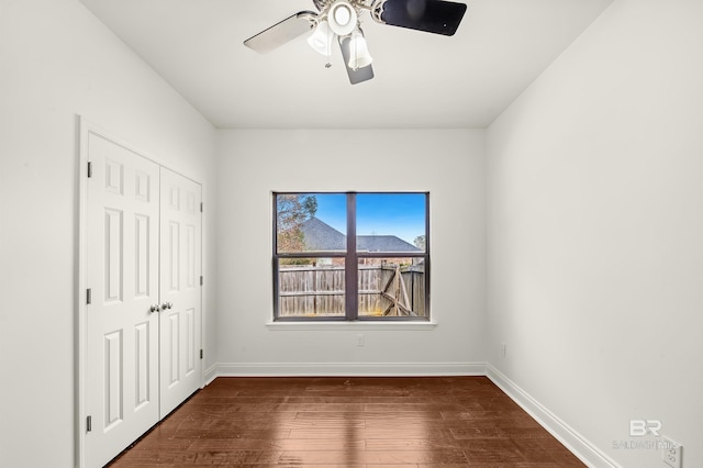 unfurnished bedroom featuring ceiling fan, a closet, wood-type flooring, and baseboards