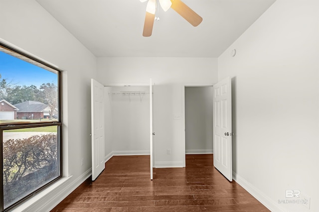 unfurnished bedroom with a closet, wood finished floors, a ceiling fan, and baseboards