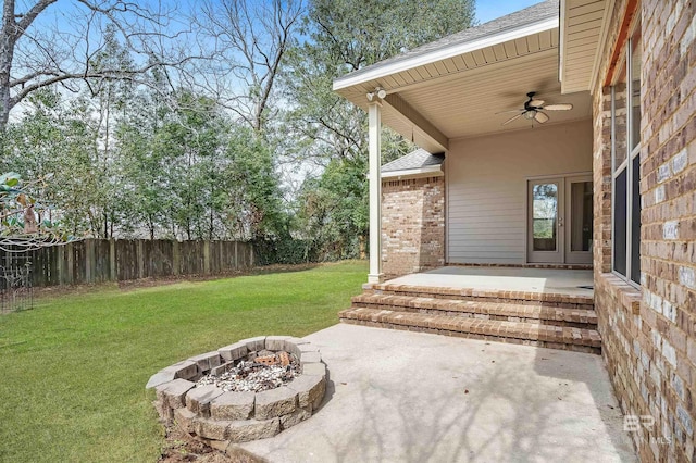 view of patio with ceiling fan, an outdoor fire pit, and fence