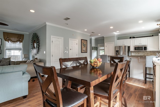 dining space with crown molding and dark hardwood / wood-style floors