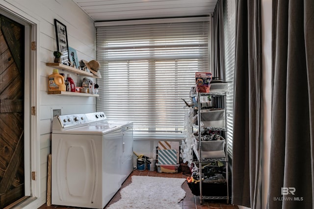 clothes washing area with washing machine and clothes dryer and tile patterned floors