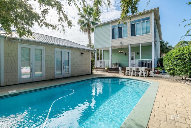 view of swimming pool featuring a patio area and french doors