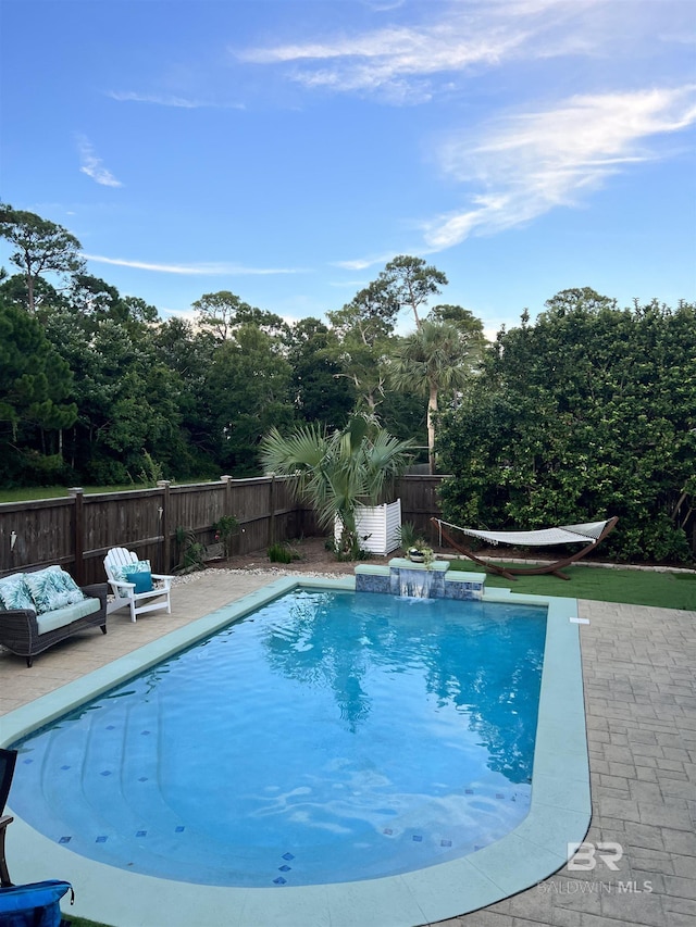 view of pool featuring pool water feature and a patio