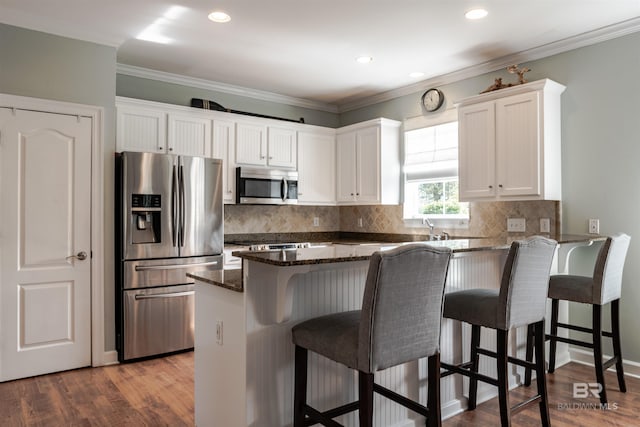 kitchen with white cabinetry, stainless steel appliances, dark wood-type flooring, and dark stone counters